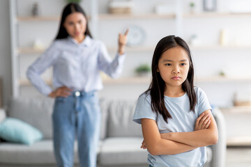 Family conflict. Mother and daughter quarreling at home, girl ignoring her mom, standing back to...