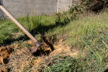 Fototapeta premium detail of a hoe digging and lifting up the soil