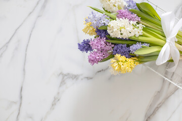 Bouquet of spring colored flowers of hyacinths. White marble background.