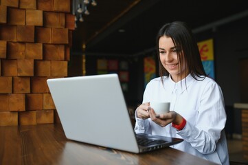 Fototapeta na wymiar Business entrepreneur girl working online on laptop in cafe.