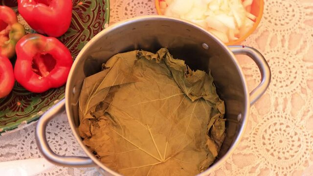People cook dolma food.
Grape leaves stuffed with minced meat.