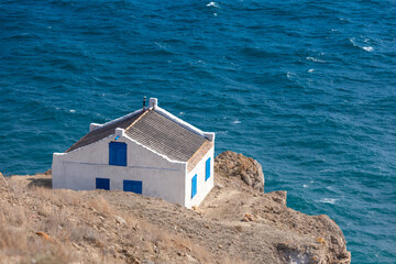 Simple little house on the edge of a cliff overlooking the sea