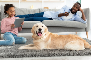 Black family spending time together at home with dog