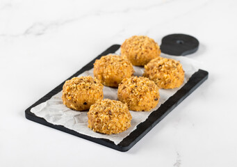 Round nut cookies on a serving board on a white background