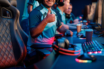 Fototapeta na wymiar Medium shot of young professional esports player showing approval gesture during participation in international gaming event in computer club