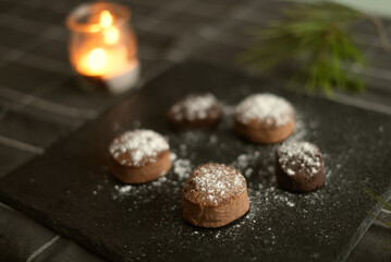 Variety of mantecados mantecados, polvorones, nevaditos on the plate decorated with a white fir tree and lights in the background. Typical sweets that are consumed at Christmas time in Spain.