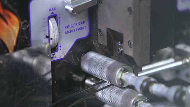 Cutting an electrical cable by a machine in production.