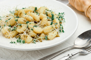 potato gnocchi with flour, green peas and parmesan cheese on a white background,italian cuisine, italian food