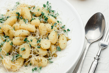 potato gnocchi with flour, green peas and parmesan cheese on a white background,italian cuisine, italian food