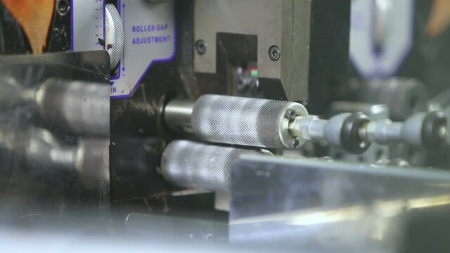 Cutting an electrical cable by a machine in production.
