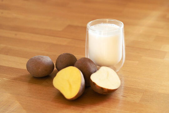 Potato milk photo on wooden background. Glass of alternative milk. Plant based vegetarian beverage. Lactose free drink