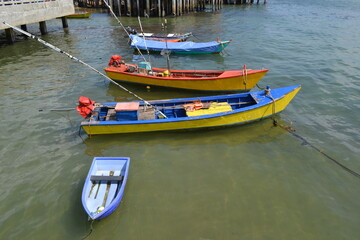 Fototapeta na wymiar four multicolored boats on the coast of the Seam Bay in Thailand