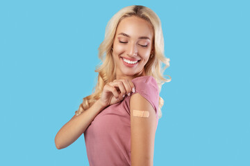 Happy Vaccinated Woman Looking At Shoulder With Adhesive Bandage