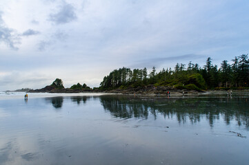 Fototapeta na wymiar People walking on the sandy beach in Cox Bay, Tofino Vancouver Island Canada.