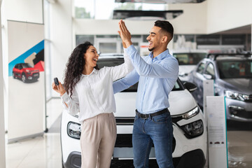 Emotional middle-eastern lovers giving high five, buying new auto