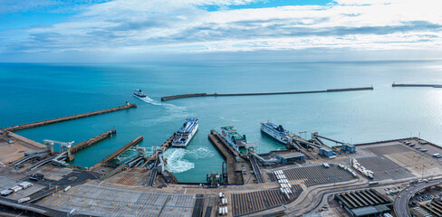 Aerial view of the Dover harbor with many ferries and cruise ships entering and exiting Dover, UK.