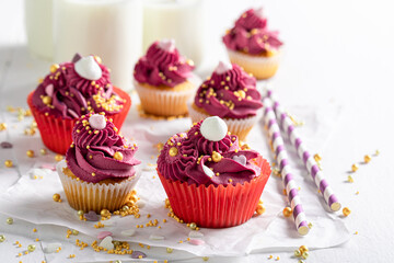 Beautiful red cupcakes with golden sprinkles and cream.