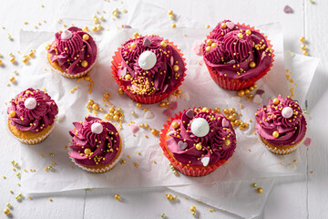 Sweet red cupcakes made of sprinkles and whipped cream.