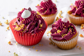 Tasty red cupcakes made of strawberries and golden sprinkles.