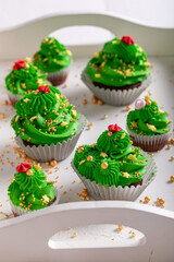 Tasty green cupcakes with golden sprinkles and cream.