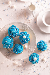 Tasty blue cupcakes with flower shaped cream.
