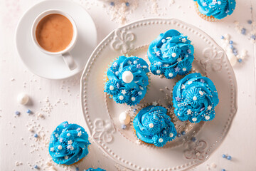 Unique blue cupcakes with cream and sprinkles for fat thursday.