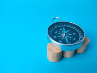 Block cylinder and compass on a blue background. with copy space.