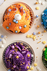 Unique multicolored cupcakes with sprinkles and colored cream.