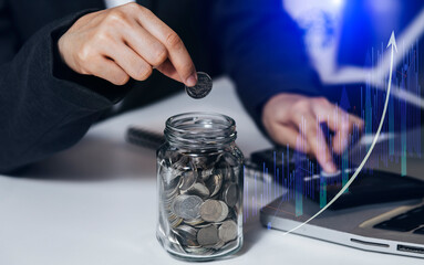 Business investment growth and saving money concept. businesswoman hands holding coins and putting in to the glass .