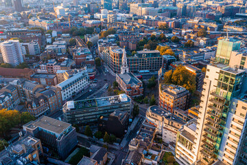 Aerial panorama of the London city financial district with many iconic skyscrapers near river Thames at sunset.