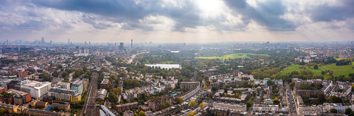Fototapeta na wymiar Beautiful aerial view of London with many green parks and city skyscrapers in the foreground.