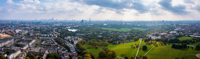Fototapeta na wymiar Beautiful aerial view of London with many green parks and city skyscrapers in the foreground.