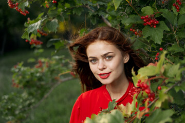 cheerful woman in a red shirt bush berries countryside