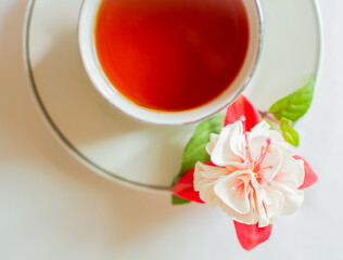 Cup of tea with a flower on a saucer