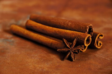fragrant Indian spices cinnamon sticks and star anise close up on a brown background