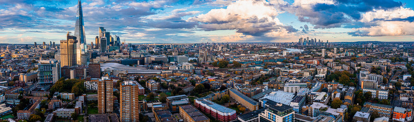 Aerial panorama of the London city financial district with many iconic skyscrapers near river Thames at sunset.
