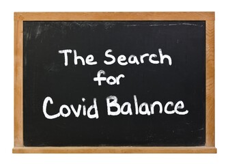 The Search for Covid Balance written in white chalk on a black chalkboard isolated on white