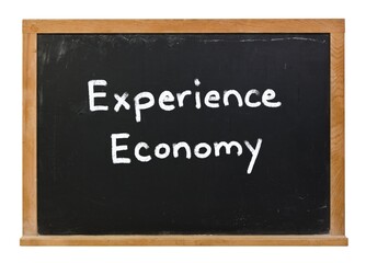 Obraz premium Experience Economy written in white chalk on a black chalkboard isolated on white