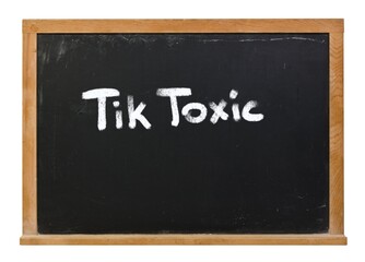 Obraz premium Tik Toxic written in white chalk on a black chalkboard isolated on white