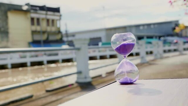 The hourglass stood on the rough rock surface near the rising tide canal. It shows that the flowing water never flows back. time too