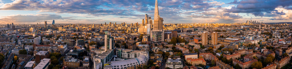 Aerial panorama of the London city financial district with many iconic skyscrapers near river Thames at sunset.