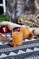 Apple spiced cider served on ice with apple and cinnamon