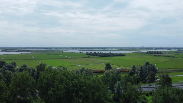 Aerial reveal shot of traffic, fields and Kagerplassen in South Holland, the Netherlands