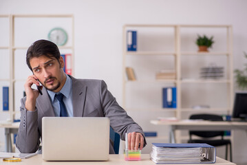 Obraz premium Young male employee working in the office