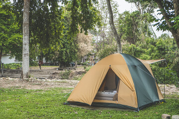 Camping picnic green tent campground in outdoor hiking forest.  Camper while campsite in nature background at summer trip camp. Adventure Travel Vacation concept