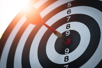 bullseye has red dart arrow throw hitting the center of a shooting for business targeting and winning goals business.