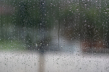 Blurred rain drops through glass
