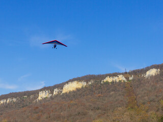 Fototapeta na wymiar Flying a motorized hang glider on an autumn sunny day.