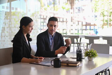 Businessman negotiating about business project with his business partner in modern workplace.