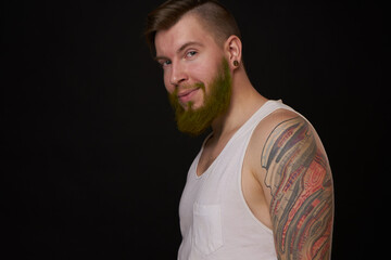 bearded man in white t-shirt with tattoos on his arms posing bully